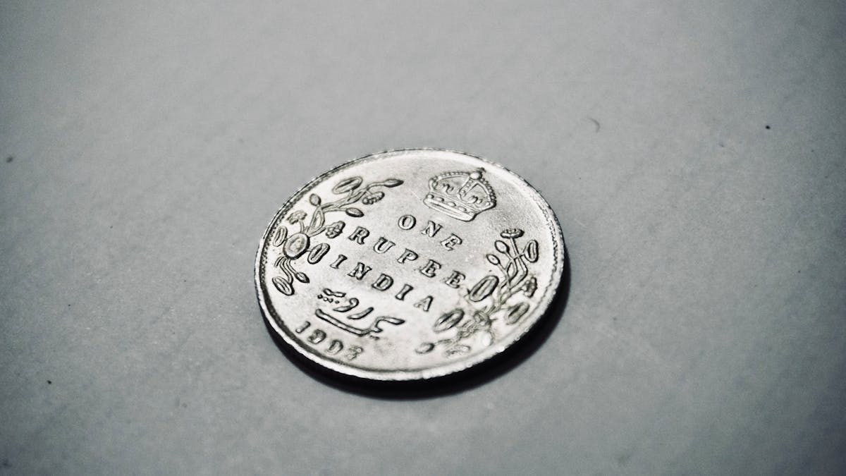 Close-up photograph of a 1907 silver Indian rupee coin with intricate details.